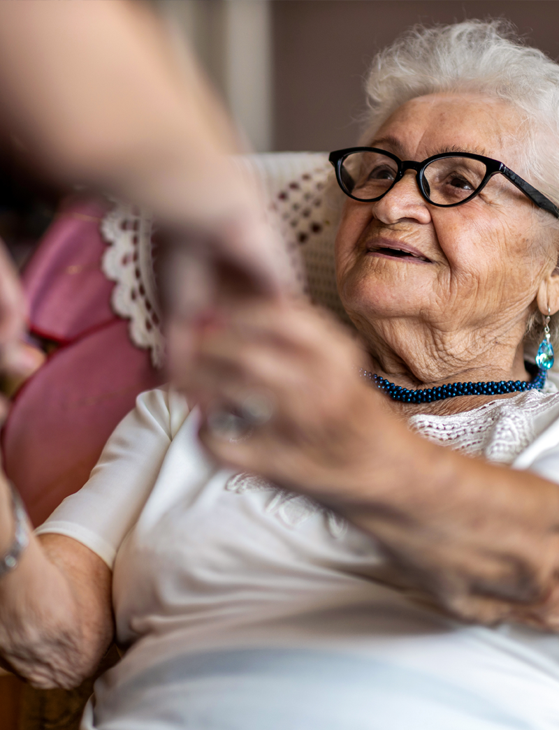 Senior getting helped up by a caregiver